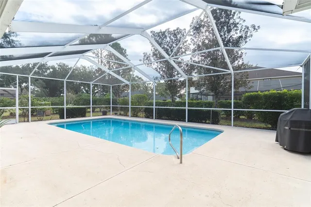 a view of a swimming pool with a yard and wooden fence