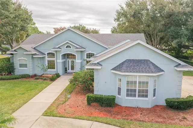 a front view of a house with a yard and trees
