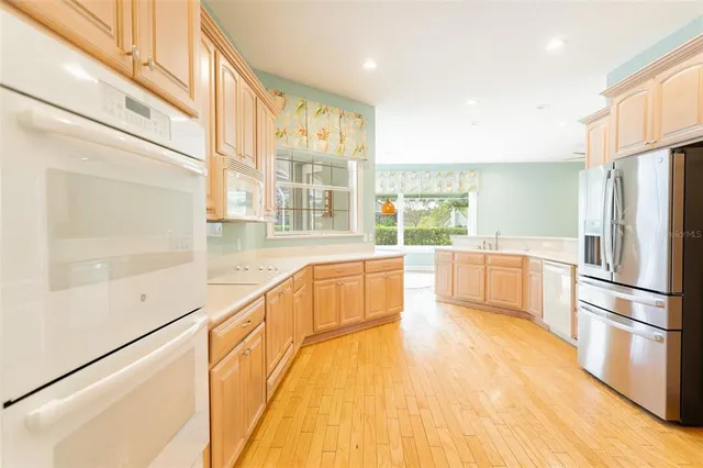 a large white kitchen with a large window