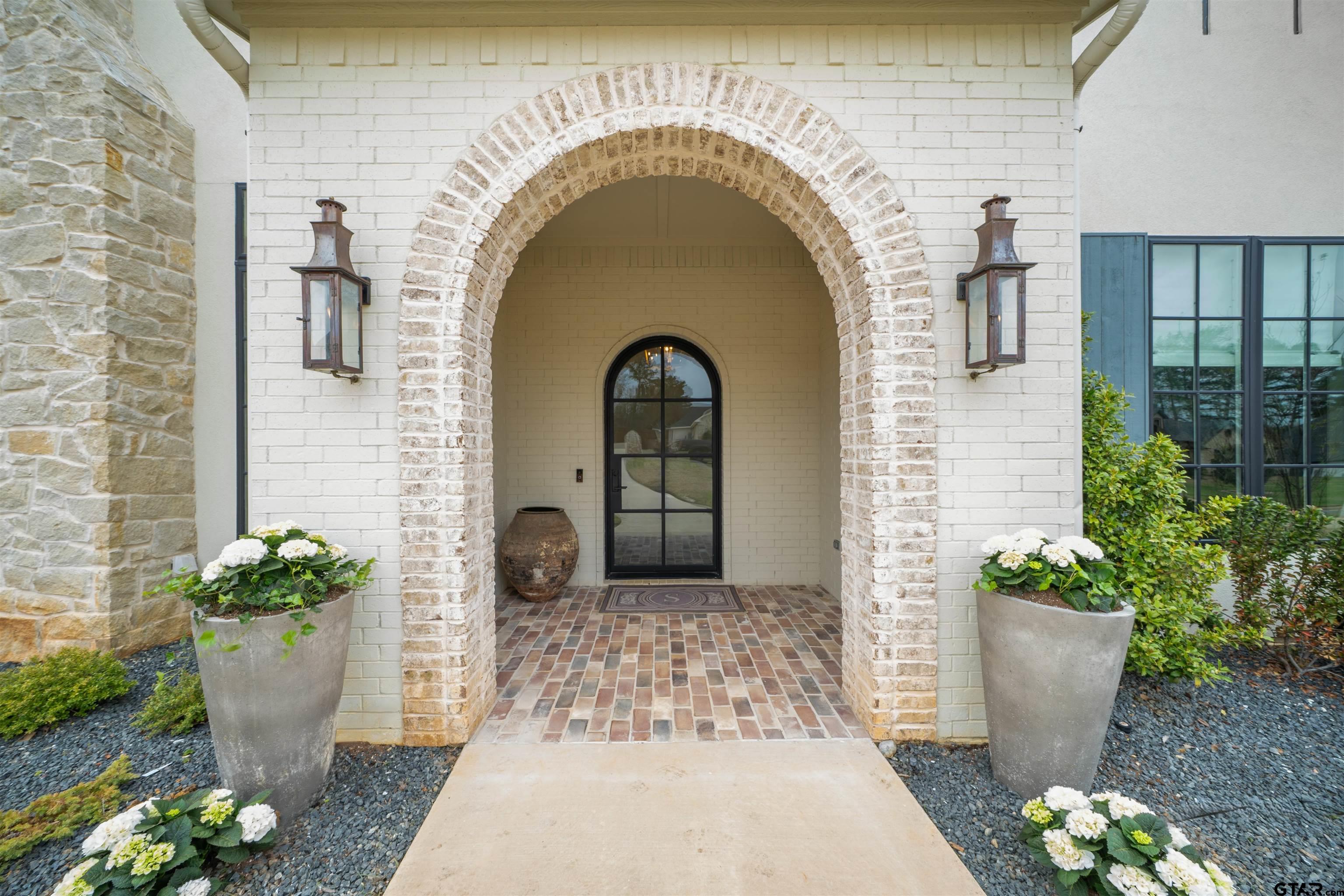 1555 Chaparrel Run Tyler, TX 75703 - Photo 2 of 48 a front view of a house with potted plants