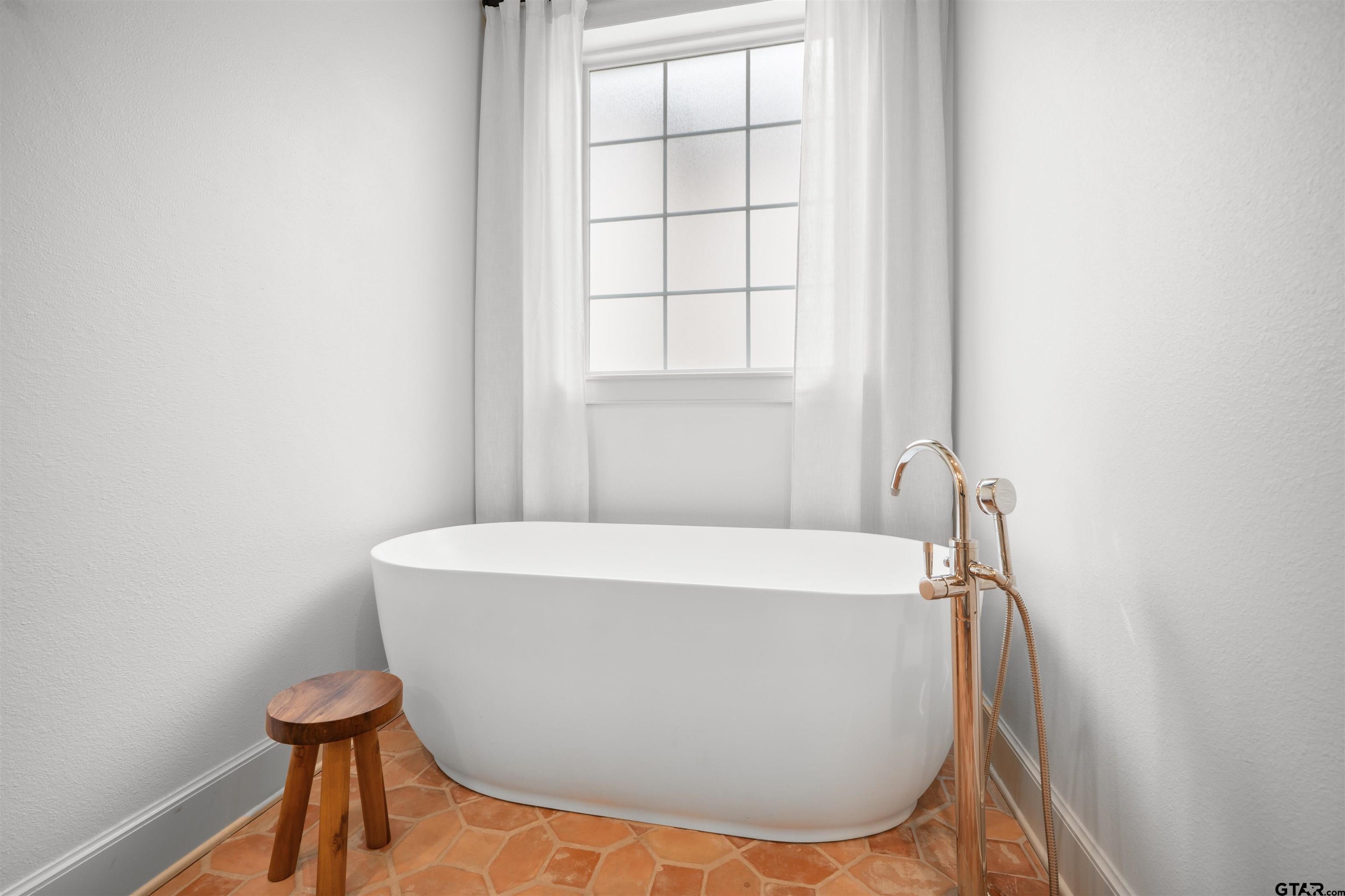 1555 Chaparrel Run Tyler, TX 75703 - Photo 21 of 48 a white bath tub sitting in a bathroom