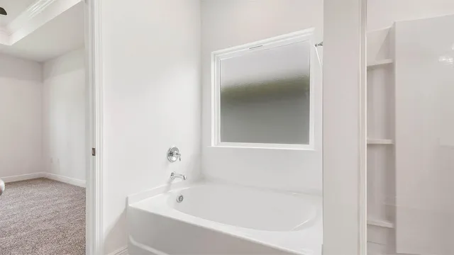 a white bath tub sitting next to a white wooden cabinet