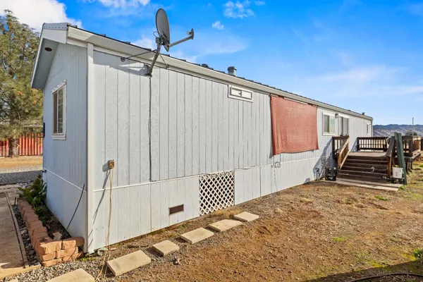 a view of a house with wooden deck and a big yard