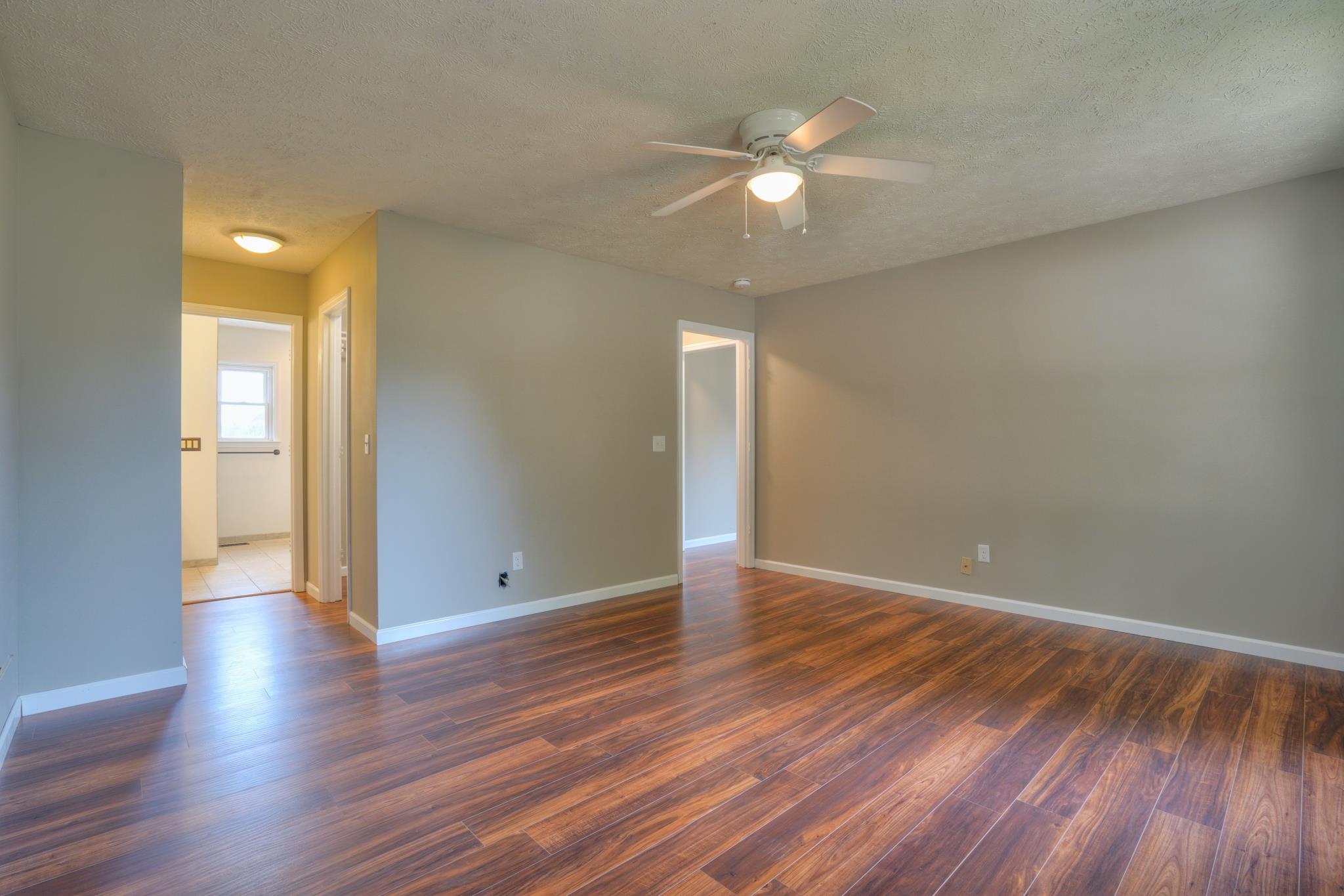 612 Murrell Road Dickson, TN 37055 - Photo 14 of 29 a view of an empty room with wooden floor and a chandelier fan
