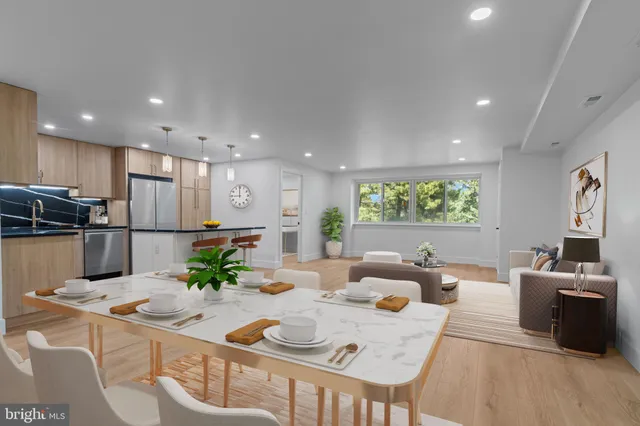 a kitchen with stainless steel appliances kitchen island granite countertop a sink and a refrigerator