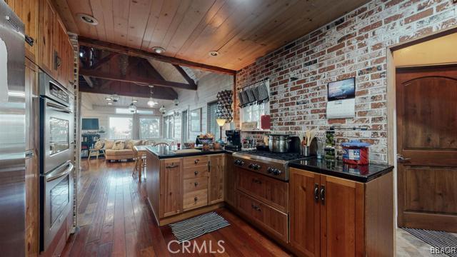 22013 Mojave River Road Cedarpines Park, CA 92322 - Photo 7 of 22 a kitchen with stainless steel appliances granite countertop lots of counter top space and wooden floor