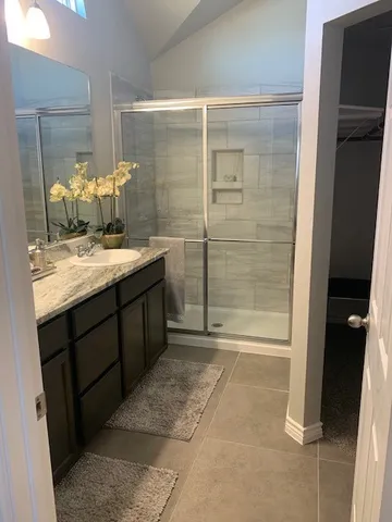 a bathroom with a granite countertop sink a toilet and shower
