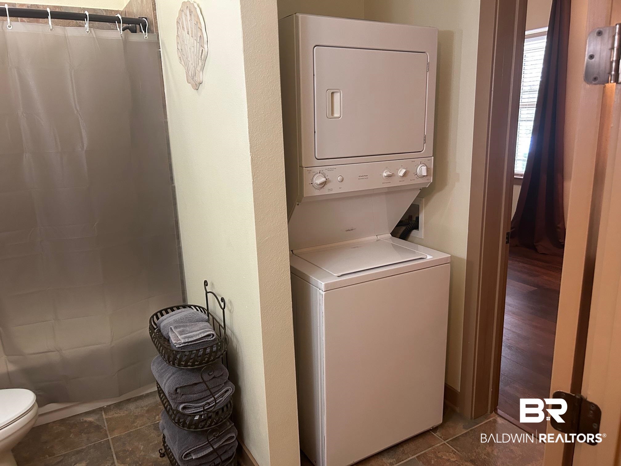1430 Regency Road, Unit J102 Gulf Shores, AL 36542 - Photo 10 of 11 Clothes washing area featuring stacked washer and clothes dryer