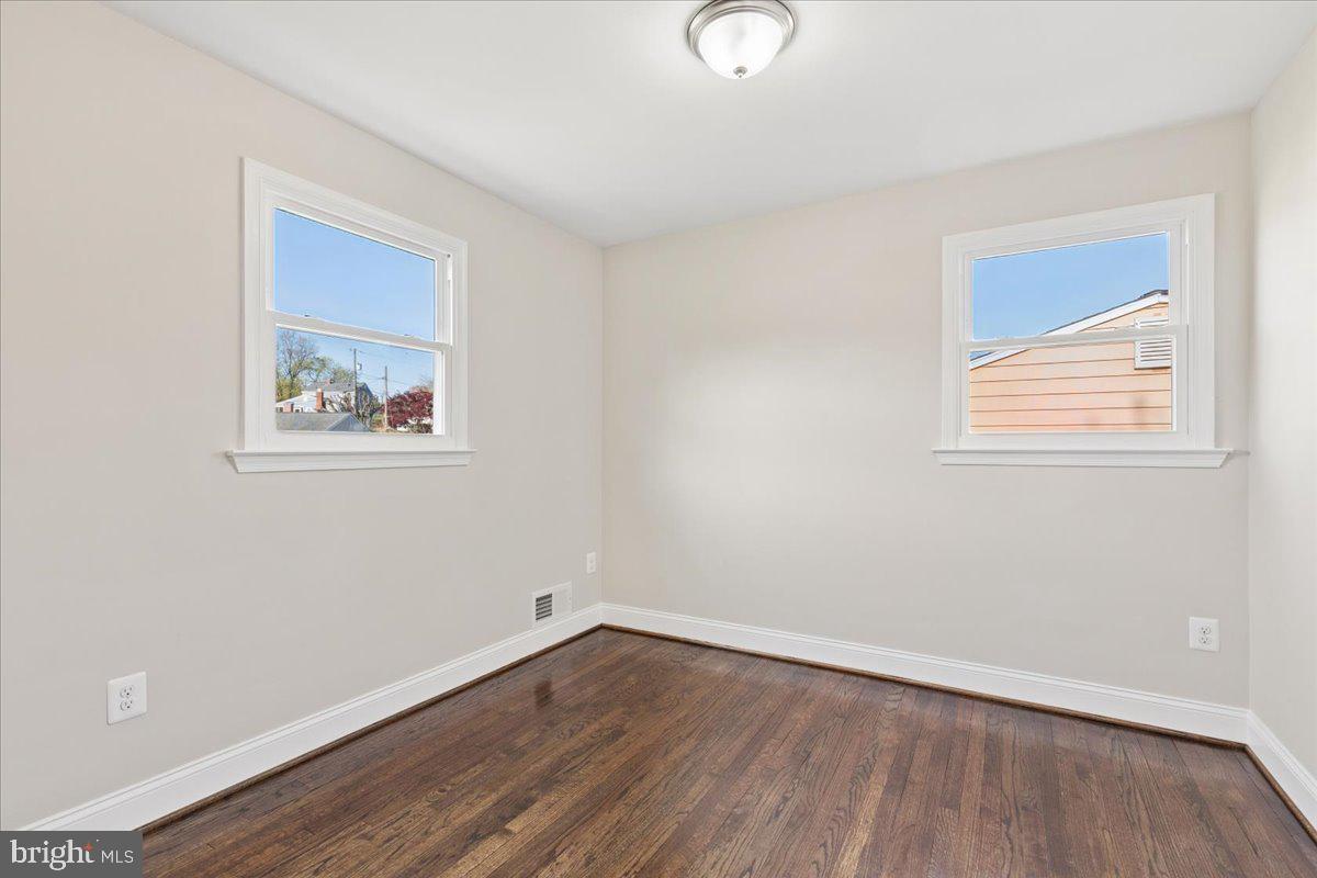 216 Cheddington Road Linthicum Heights, MD 21090 - Photo 15 of 60 an empty room with wooden floor and windows