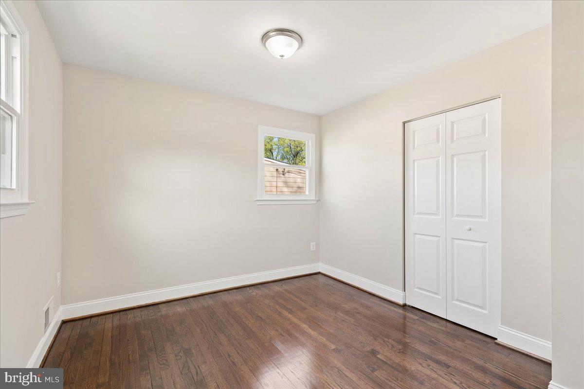 216 Cheddington Road Linthicum Heights, MD 21090 - Photo 16 of 60 an empty room with wooden floor and windows