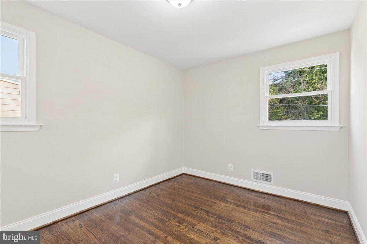 216 Cheddington Road Linthicum Heights, MD 21090 - Photo 19 of 60 an empty room with wooden floor and windows