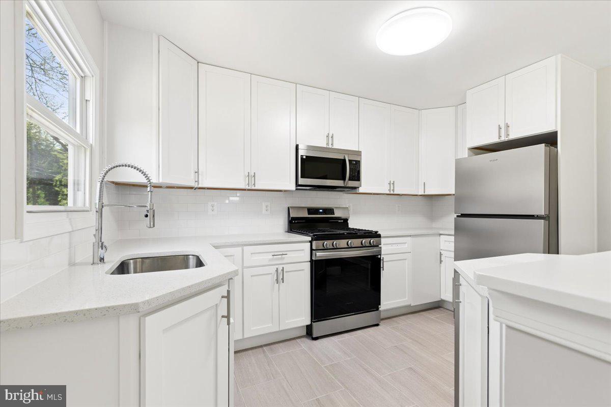 216 Cheddington Road Linthicum Heights, MD 21090 - Photo 30 of 60 a kitchen with a sink white stove and refrigerator