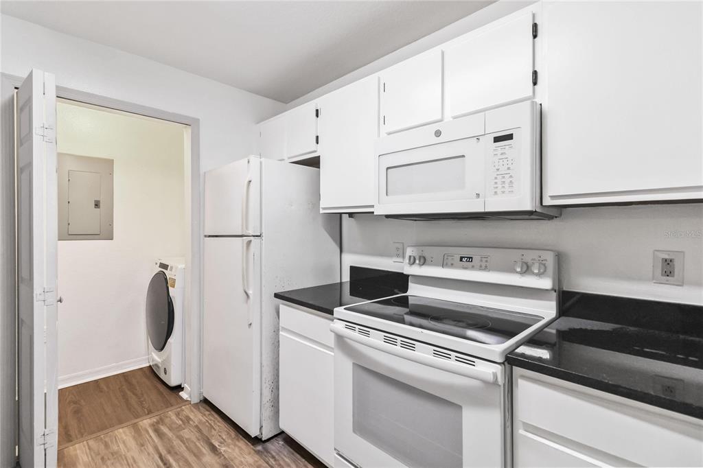 5459 Vineland Road, Unit 4208 Orlando, FL 32811 - Photo 12 of 29 a view of cabinets a sink and a refrigerator in a kitchen