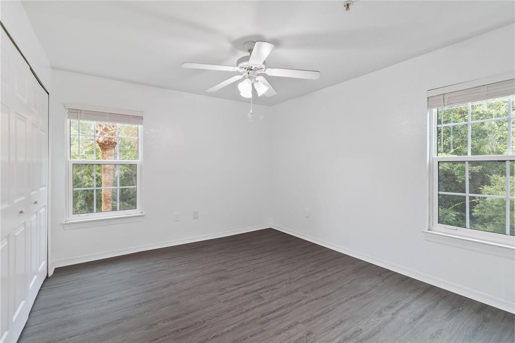 5459 Vineland Road, Unit 4208 Orlando, FL 32811 - Photo 22 of 29 an empty room with wooden floor chandelier fan and windows