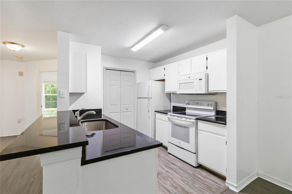 5459 Vineland Road, Unit 4208 Orlando, FL 32811 - Photo 10 of 29 a kitchen with stainless steel appliances a stove a sink and a refrigerator