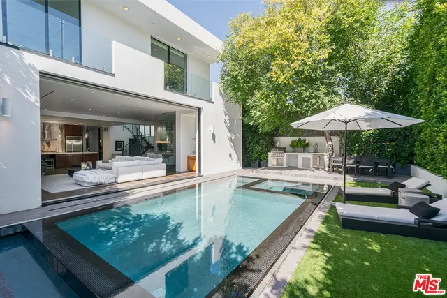 a view of a patio with couches table and chairs with an umbrella