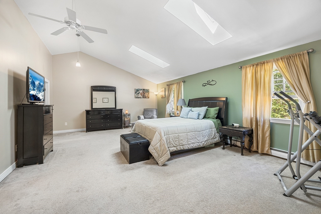 620 Whitney Street Gardner, MA 01440 - Photo 23 of 39 a spacious bedroom with a large bed and a chandelier