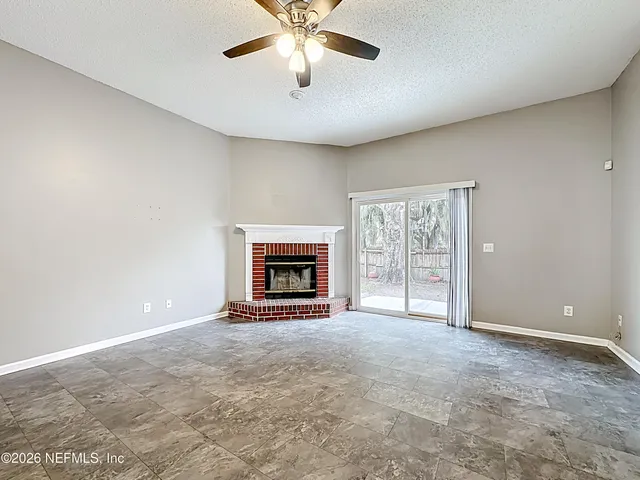 an empty room with windows and fireplace
