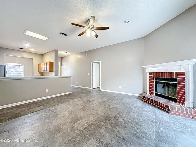 a view of an empty room with a fireplace and a window