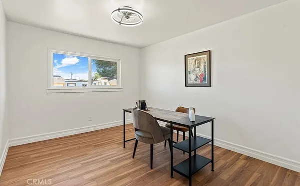 a view of a workspace with furniture and wooden floor