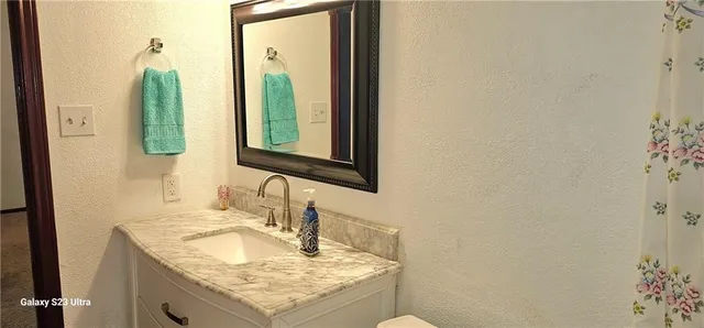 a bathroom with a granite countertop sink and a mirror