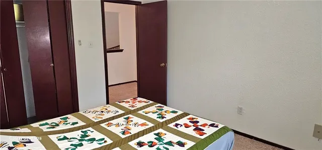 a bedroom with a bed and a lamp on dresser