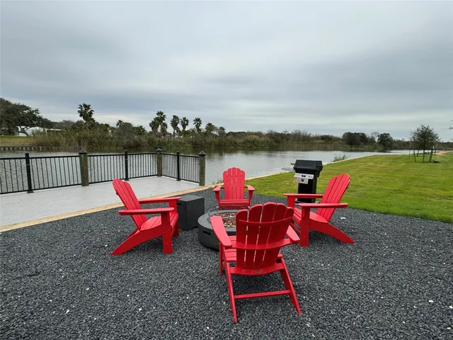 an outdoor sitting area with furniture and lake view