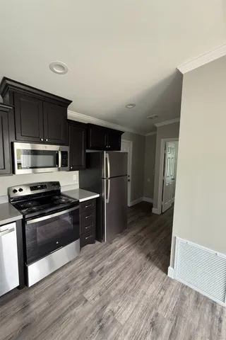 a kitchen with stainless steel appliances granite countertop a stove a refrigerator and a microwave