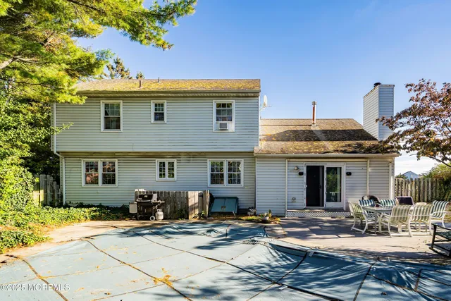 a view of a house with backyard and sitting area