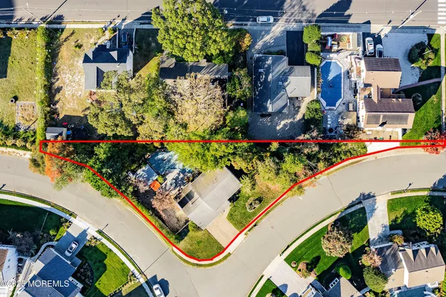 an aerial view of a residential apartment building with a yard and garden