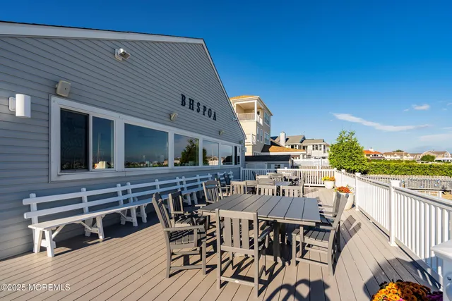 a view of a patio with couches table and chairs with wooden floor and fence