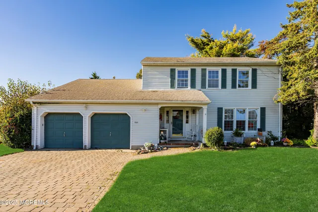 a front view of a house with a garden and plants