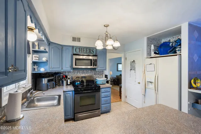 a kitchen with stainless steel appliances a stove a sink and a microwave