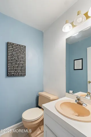 a bathroom with a toilet a sink and mirror