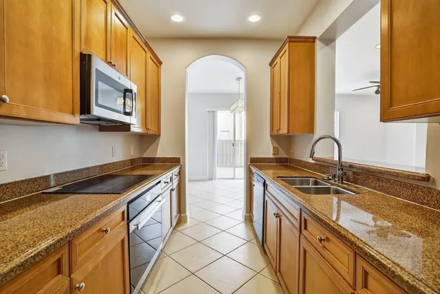 a kitchen with stainless steel appliances granite countertop a sink and a stove