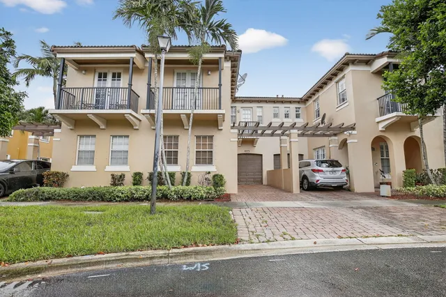 a view of a white house with a yard and plants