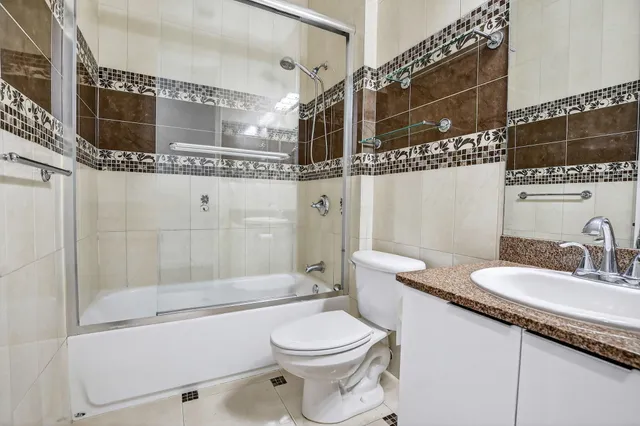 a bathroom with a granite countertop sink toilet and shower