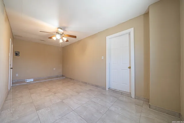 an empty room with chandelier fan