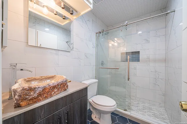 a bathroom with a sink toilet and shower