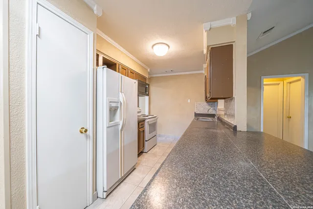 a view of hallway with furniture and a refrigerator