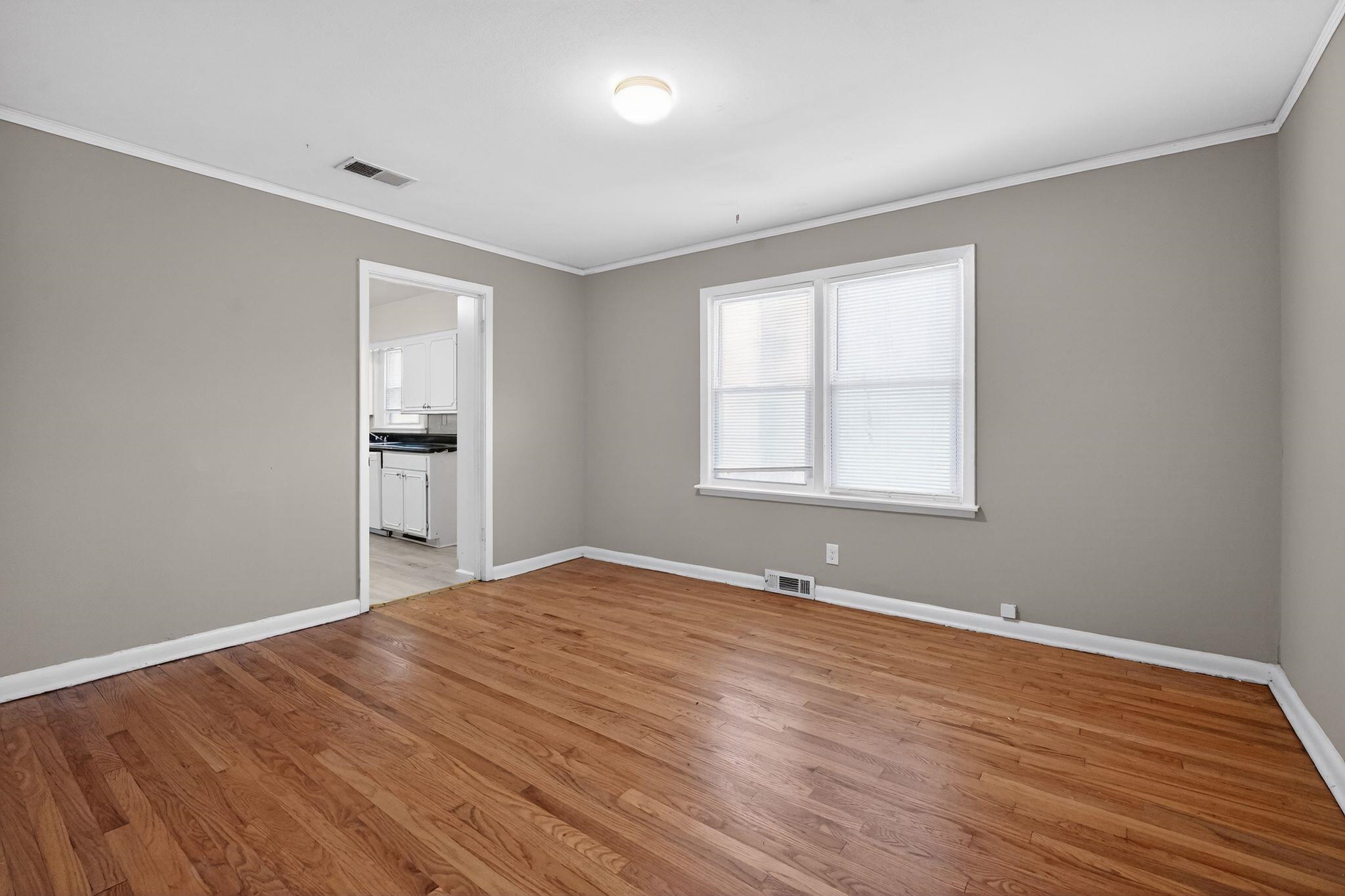 4094 Auburn Road Memphis, TN 38116 - Photo 5 of 30 a view of an empty room with wooden floor and a window