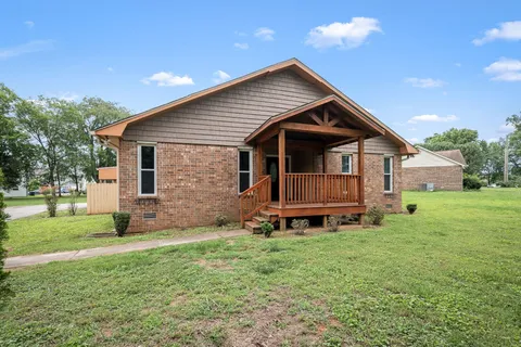 a view of a porch with wooden floor and a swing