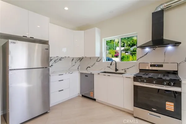 a kitchen with stainless steel appliances a stove a sink and a microwave
