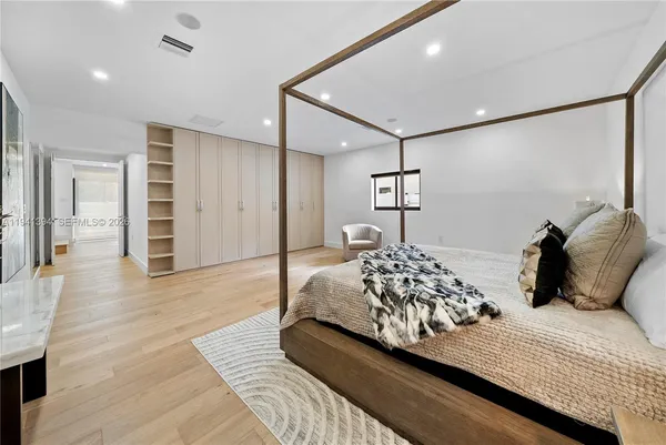 a bedroom with a large bed and a chandelier