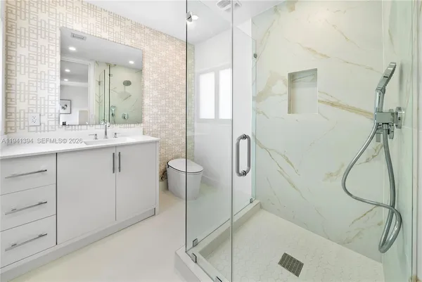 a bathroom with a granite countertop sink a mirror and a shower