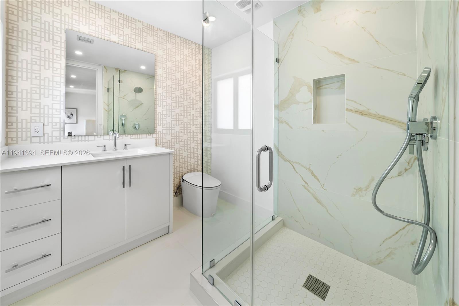 600 Northeast 57th Street Miami, FL 33137 - Photo 25 of 43 a bathroom with a granite countertop sink a mirror and a shower