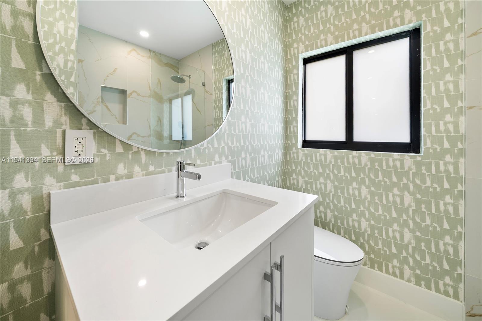 600 Northeast 57th Street Miami, FL 33137 - Photo 28 of 43 a bathroom with a sink a toilet and mirror