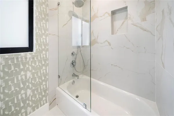 a bathroom with a bathtub and shower