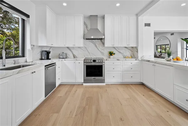 a kitchen with stainless steel appliances a stove sink and cabinets