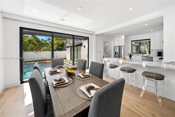 a view of a dining room with furniture large windows and wooden floor